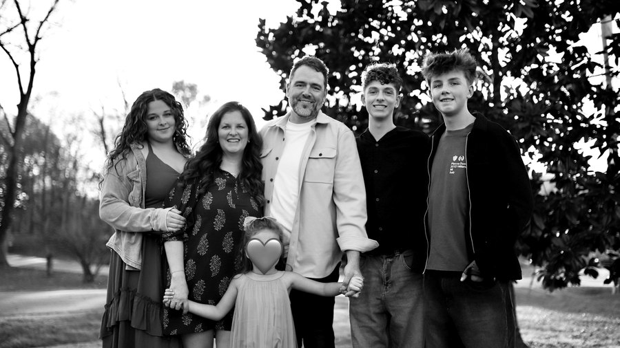 Kyle Chowning with his wife Kristy and their children, outdoors.